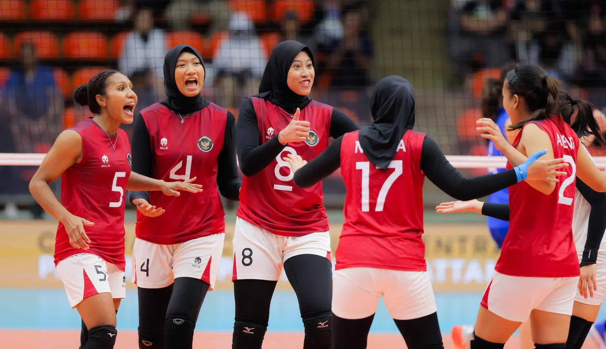Tim voli Putri Indonesia akhirnya mampu keluar dari tekanan sekaligus mengamankan set pertama dengan kemenangan tipis 28-26. Tampak dalam foto, pemain Timnas Voli Putri Indonesia, Megawati Hangestri Pertiwi (tengah) merayakan raihan poin saat bertanding di final voli putri SEA Games 2025 di Indoor Stadium Huamark, Bangkok, Thailand, pada Senin (15/12/2025). (Bola.com/Bagaskara Lazuardi)