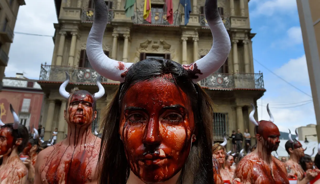 Sejumlah aktivis membasahi wajahnya dengan darah palsu saat aksi menolak festival San Fermin di Pamplona, Spanyol, (5/7). Festival yang menampilkan tradisi lari bersama banteng dan matador ini merupakan aksi yang mengorbankan hewan. (REUTERS/Susana Vera)