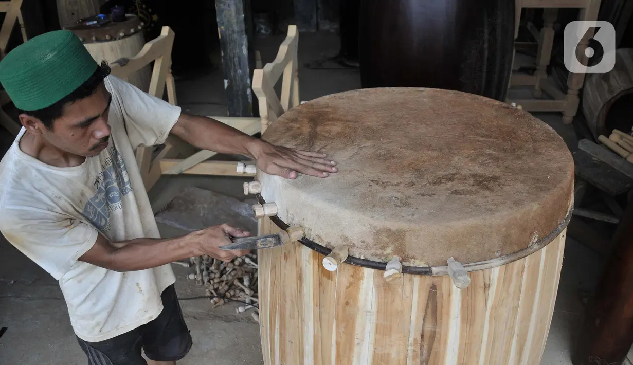<p>Perajin menyelesaikan pembuatan beduk Al Mubarok di Desa Gumulung, Kecamatan Greged, Kabupaten Cirebon, Jawa Barat pada akhir Maret 2022 lalu. Sudah puluhan tahun Desa Gumulung terkenal sebagai sentra kerajinan beduk di Cirebon. Salah satu generasi penerus, yakni Amin Mubarok (30) mengungkapkan beduk buatannya telah tersebar di berbagai kota di Indonesia, bahkan sudah mencapai Taiwan. (merdeka.com/Iqbal S Nugroho)</p>