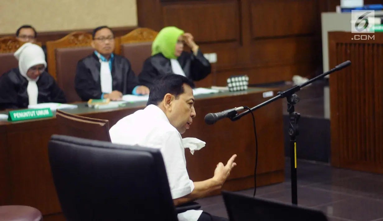 Tersangka korupsi proyek E-KTP Setya Novanto memberi kode saat mengikuti sidang perdana di Pengadilan Tipikor, Jakarta, Rabu (13/12). Sidang diskors untuk melakukan pemeriksaan kesehatan terhadap Setya Novanto. (Liputan6.com/Helmi Fithriansyah)