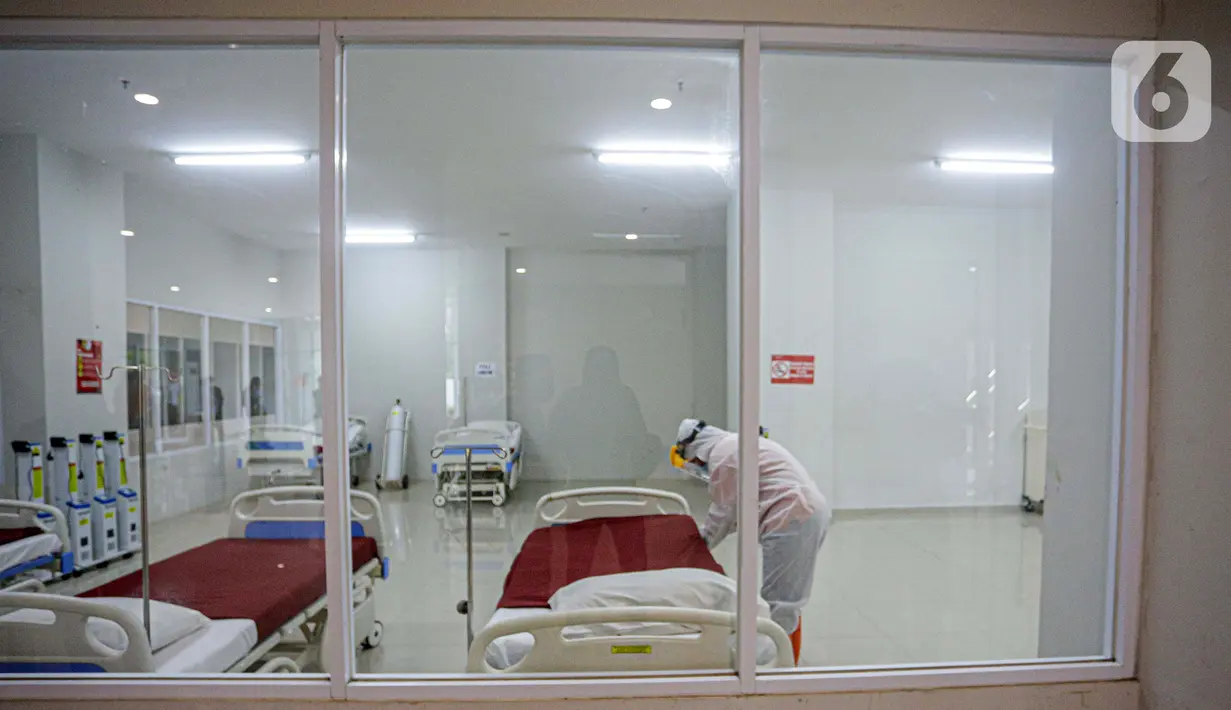 Petugas mengenakan hazmat saat menyiapkan tempat tidur di Tower 8 Wisma Atlet Pademangan, Jakarta, Selasa (15/6/2021). Koordinator Lapangan RSDC Wisma Atlet Letkol Marinir M. Arifin mengatakan soal alternatif Tower 8 Wisma Atlet Pademangan untuk pasien OTG COVID-19. (Liputan6.com/Faizal Fanani)