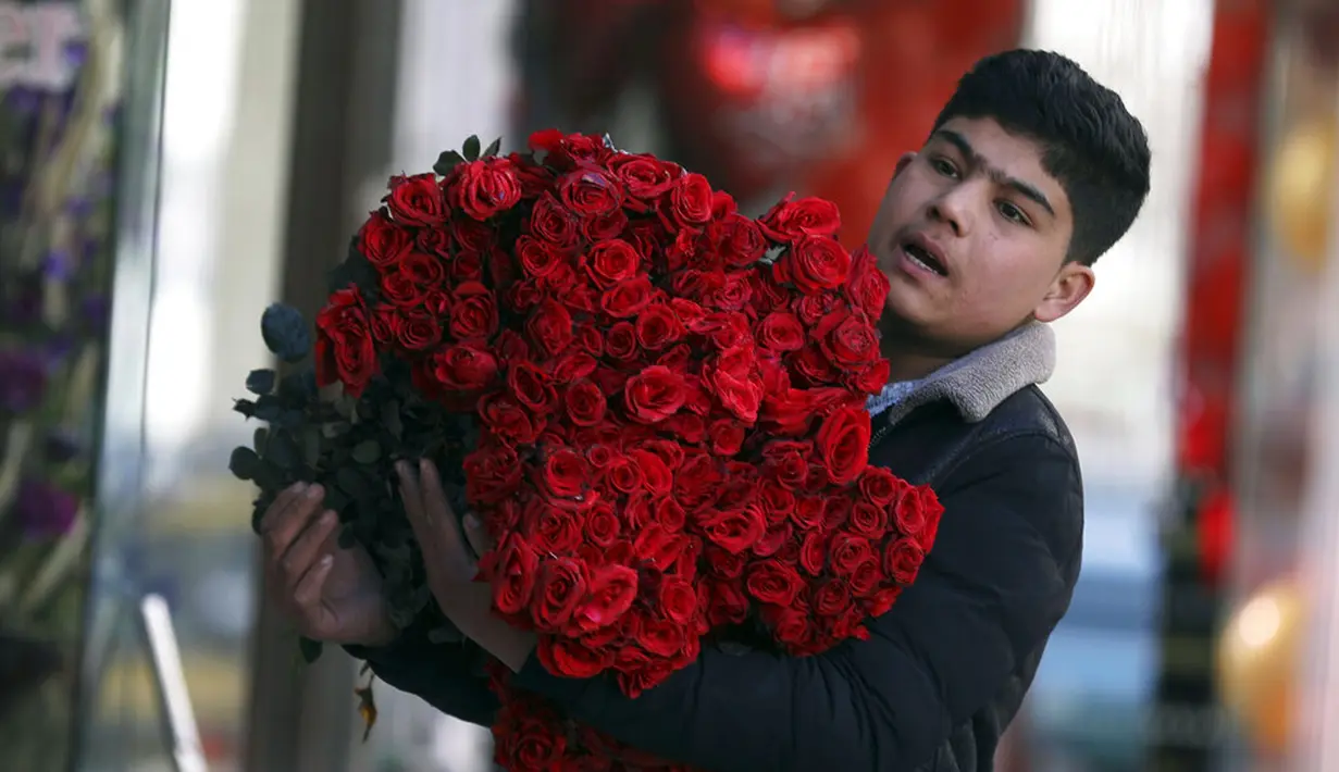 Seorang anak laki-laki membawa mawar pada Hari Valentine di Kabul, Afghanistan, Minggu (14/2/2021). Hari Valentine menjadi budaya baru dalam masyarakat Afghanistan yang konservatif. (AP Photo/Rahmat Gul)