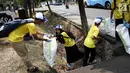 Sejumlah relawan membersihkan sampah di kawasan Taman Mini Indonesia Indah (TMII), Jakarta, Sabtu (15/9). Gerakan World Cleanup Day 2018 yang digelar Indofood bertujuan meningkatkan kesadaran masyarakat menjaga lingkungan. (Liputan6.com/Fery Pradolo)