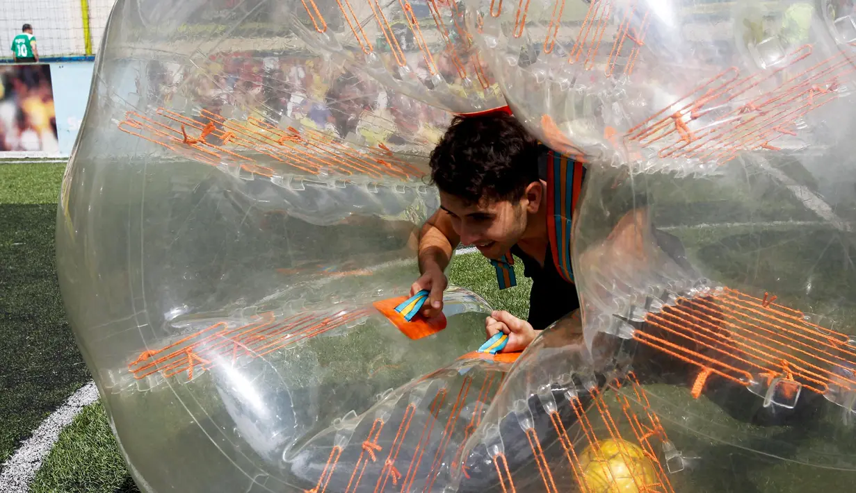Seorang peserta bersusah payah menegakkan badannya saat mengikuti turnamen sepakbola di Medellin, Kolombia, Sabtu (10/10/2015). Mereka saling berebut bola untuk mencetak gol ke gawang lawannya. (REUTERS/Fredy Builes)