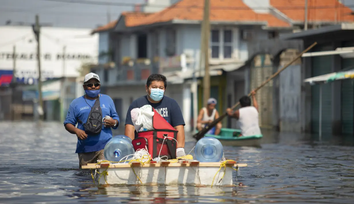 Warga menyusuri jalan-jalan yang banjir dengan rakit darurat di Villahermosa, Meksiko, Rabu (11/11/2020). Banjir telah mempengaruhi ribuan orang di negara bagian pantai Teluk Tabasco. (AP Photo/Felix Marquez)