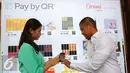 CEO Dimo Pay Indonesia Brata Rafly (kanan) mengajarkan penggunaan QR Store saat Dimo Pop Up Market di Jakarta, Selasa (26/4). Dimo Pay Indonesia, startup mobile payment, memperkenalkan solusi pembayaran digital Pay by QR. (Liputan6.com/Angga Yuniar)