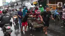 Warga mengangkut sepeda motor menggunakan gerobak melintasi banjir di jalan KH Hasyim Ashari, Kota Tangerang, Banten, Sabtu (16/7/2022). Warga sekitar membantu para pengendara yang melintas agar tidak terkena banjir dengan menawarkan jasa gerobak. (Liputan6.com/Angga Yuniar)