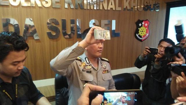 Kepala Bidang Humas Polda Sulsel, Kombes Pol Dicky Sondani memperlihatkan barang bukti kasus dugaan korupsi berupa uang dollar Singapura (Liputan6.com/ Eka Hakim)