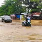 Warga mendorong sepeda motor karena mogok akibat nekat melintasi banjir di Pekanbaru. (Liputan6.com/M Syukur)