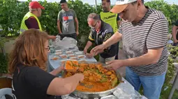 Relawan Tunisia membagikan makanan berbuka puasa gratis selama bulan suci Ramadan di Ariana dekat Tunis (7/5/2020). Masjid-masjid di Aljazair, Maroko dan Tunisia telah ditutup untuk membatasi penyebaran Covid-19, mencegah doa malam khusus. (AFP/Fethi Belad)