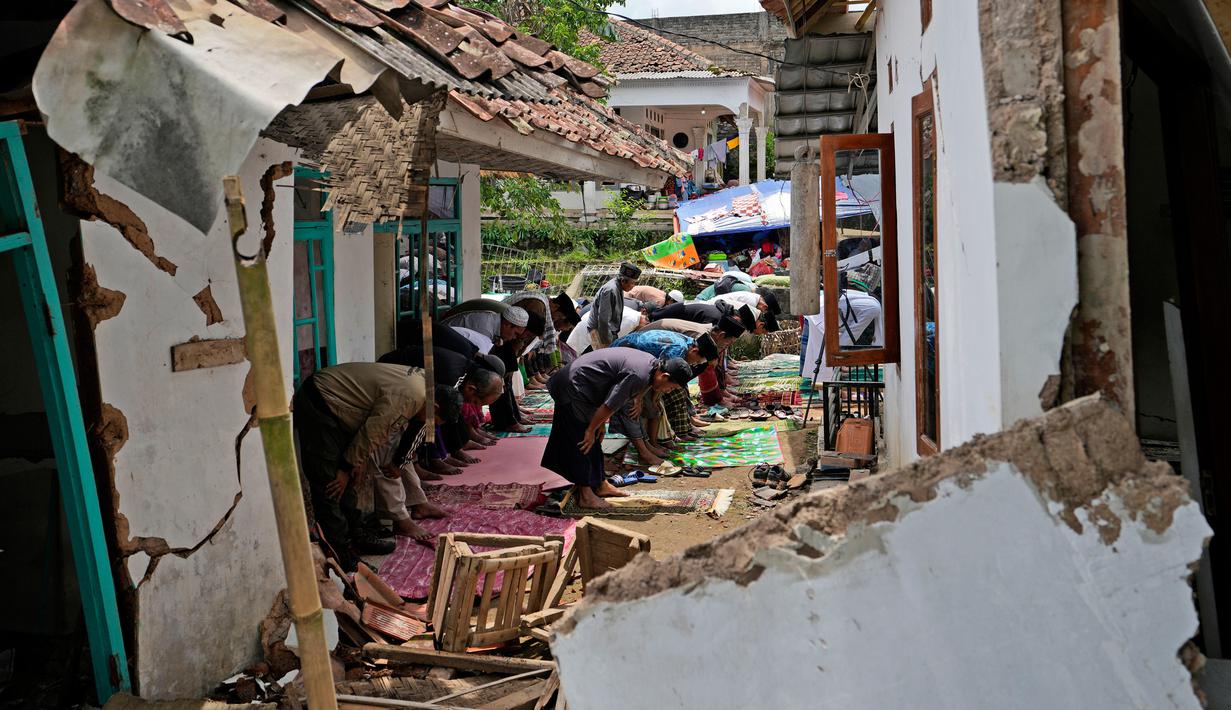 Umat muslim melaksanakan salat Jumat di tengah puing-puing masjid yang rusak akibat gempa di Desa Gasol, Cianjur, Jawa Barat, Indonesia, Jumat (25/11/2022). Gempa dengan magnitudo 5,6 yang mengguncang Cianjur pada 21 November 2022 lalu telah menewaskan 272 orang, 2.046 orang luka-luka, dan sebanyak 62.545 orang mengungsi. (AP Photo/Achmad Ibrahim)
