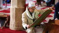 Pria Muslim membaca Al-qur'an pada hari pertama Ramadhan di Masjid Al-Kabir di ibu kota Yaman, Sanaa, 2 April 2022. Pemberontak Huthi yang didukung Iran dan koalisi pimpinan Saudi sepakat untuk mematuhi gencatan senjata dua bulan, yang mulai berlaku pada hari pertama puasa. (MOHAMMED HUWAIS/AFP)