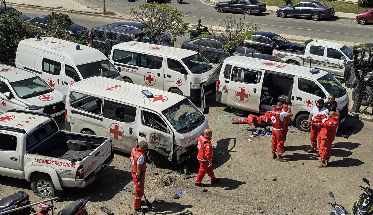 Para sukarelawan Palang Merah Lebanon memeriksa kerusakan pada ambulans penyelamat di lokasi serangan pesawat tak berawak Israel yang menargetkan markas mereka di kota Tyre, Lebanon Selatan, Senin 13 April 2026. Sebuah serangan pesawat tak berawak (drone) Israel menargetkan markas tim Palang Merah Lebanon. (Kawnat HAJU/AFP)