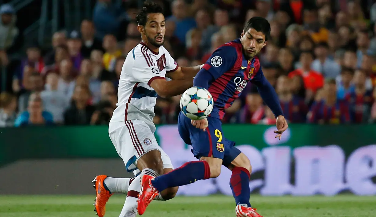 Penyerang Barcelona, Luis Suarez (kanan) berusaha melewati bek Mehdi Benatia pada leg pertama babak semifinal Liga Champions di Camp Nou, Kamis (7/5/2015). Barcelona menang 3-0 atas Bayern Muenchen. (Reuters/Paul Hanna)