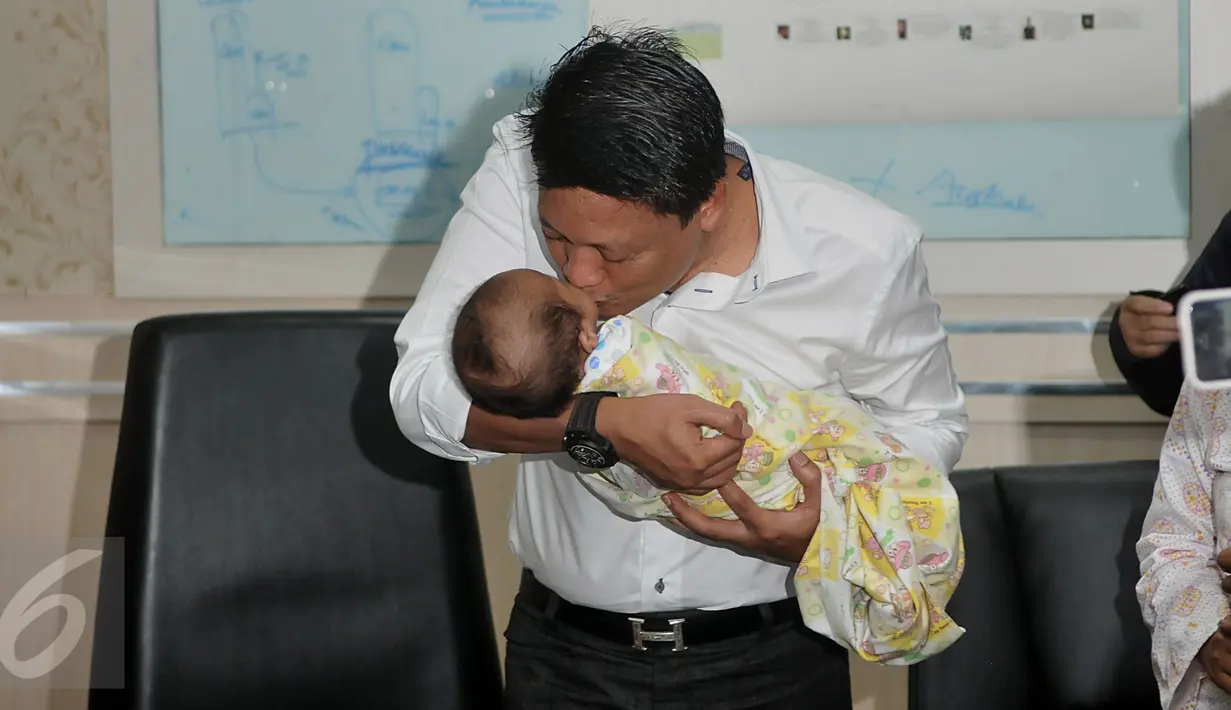 Kombes Krishna Murti mencium bayi saat memberi keterangan pers terkait sindikat penjualan bayi di Polda Metro Jaya, Jakarta, Selasa (1/3/2016). Sebelumnya, Senin (29/1) polisi menangkap 4 pelaku penculikan dan jual beli anak. (Liputan6.com/Johan Tallo)