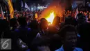 Massa aksi membakar ban saat menggelar aksi unjuk rasa di depan Istana Negara, Kamis (12/1). Namun mahasiswa bertahan dan menuntut ditemui langsung oleh Presiden Joko Widodo. (Liputan6.com/Faizal Fanani)