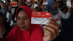 Warga menunjukkan KKS saat Penyaluran Bantuan Sosial PKH dan BPNT di Depok, Jawa Barat, Selasa (12/2). Jumlah bantuan PKH dan BPNTmencapai Rp.70.558.785.000 yang terdiri Rp26.460.225.000  untuk 21.374 KPM PKH. (Liputan6.com/Herman Zakharia)