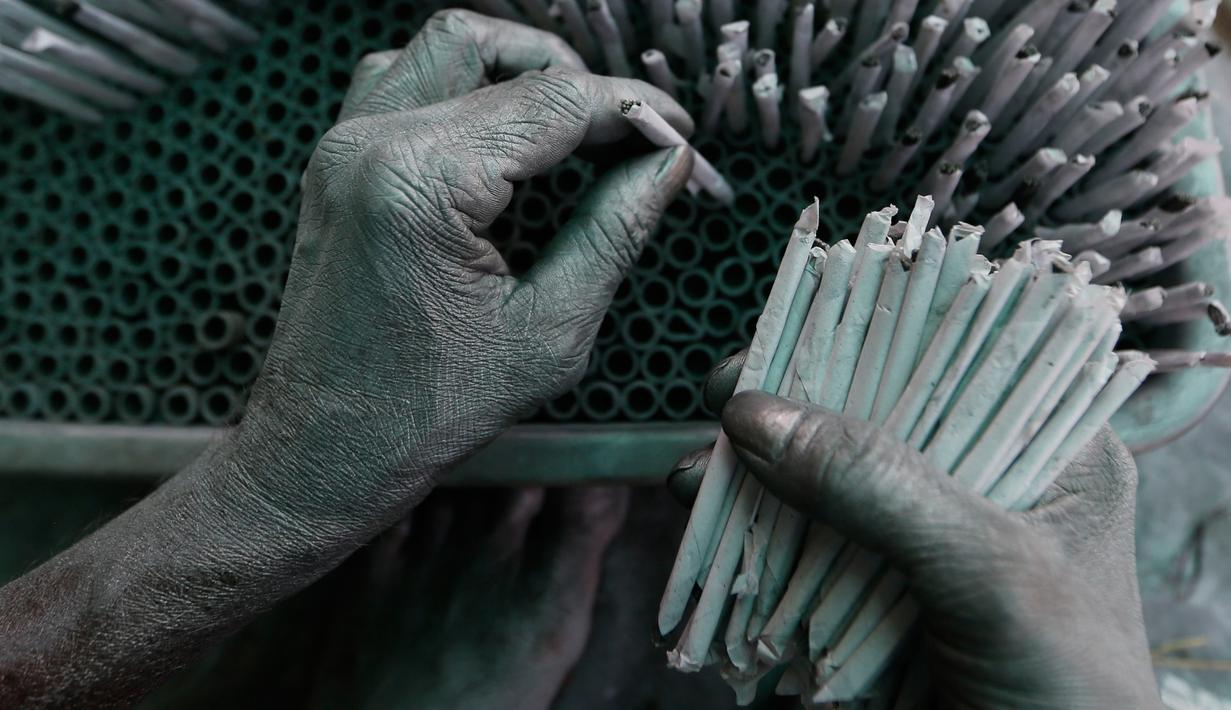 Pekerja membuat petasan untuk festival Diwali atau Dipavali bagi umat Hindu yang akan datang, di sebuah pabrik pinggiran  Ahmadabad, Senin (22/10). Permintaan petasan di India semakin meningkat jelang perayaan Festival "Cahaya" Diwali. (AP/Ajit Solanki)