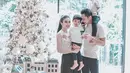 Sandra Dewi juga turut merayakan momen Natal dengan mengenakan busana nuansa putih yang serasi dengan ornamen pohon natal mereka. (Instagram/sandradewi88).