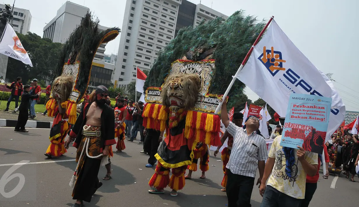 Massa aksi Hari Buruh Internasional membawa reog saat long march dari Tugu Tani ke depan Istana Merdeka hingga ke Monas, Jakarta, Senin (1/5) Dalam aksinya para buruh meminta sistem kerja kontrak dan upah rendah dihapus. (Liputan6.com/Helmi Afandi)