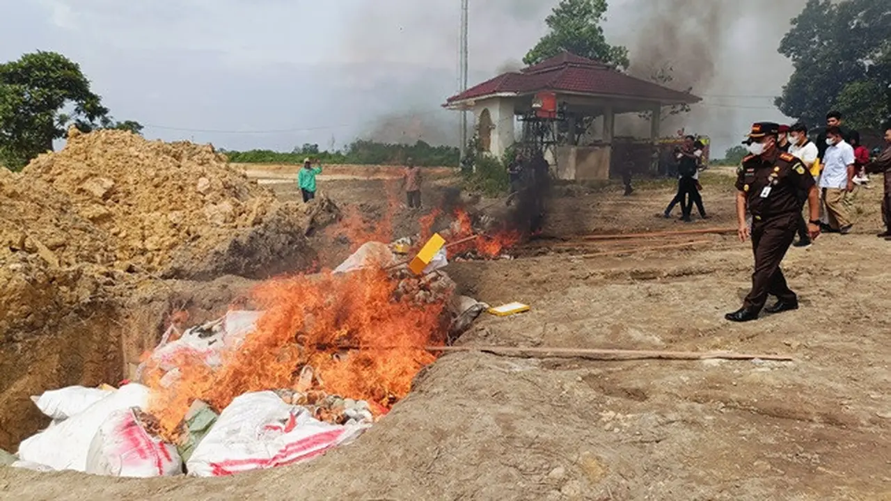 Kepala Kejari Pekanbaru melemparkan sepatu dalam pemusnahan barang bukti tindak pidana yang sudah berkekuatan hukum tetap.