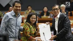 Menkumham Yasonna Laoly (kanan) menunjukkan dokumen saat rapat pleno terkait amnesti untuk Baiq Nuril dengan Komisi III DPR di Gedung Nusantara II, Jakarta, (24/7/2019). DPR setuju Presiden Joko Widodo atau Jokowi memberikan amnesti kepada Baiq Nuril. (Liputan6.com/JohanTallo)