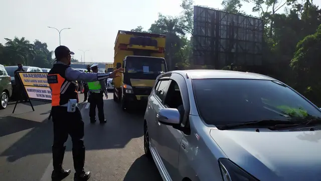 Petugas memeriksa kendaraan yang melintas di Tol Jagorawi saat hari pertama pelaksanaan PSBB di Kota Bogor