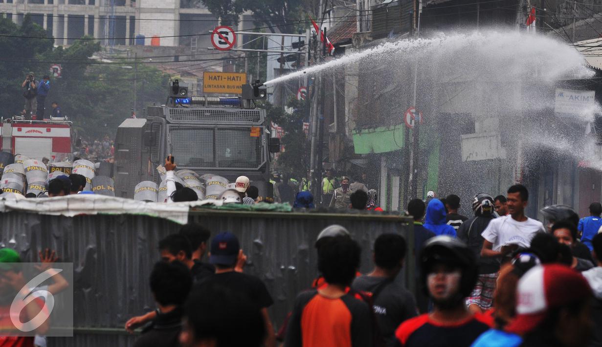 Petugas membubarkan massa dengan mengunakan water canon saat penggusuran Kampung Pulo, Jakarta, Kamis (20/8/2015). Penggusuran pemukiman Kampung Pulo dilakukan oleh 2.200 personel gabungan untuk normalisasi Sungai Ciliwung. (Liputan6.com/Herman Zakharia)