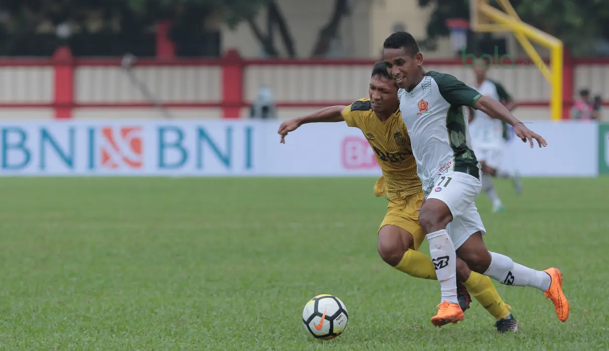 Pemain PS Tira, Pandi Lestaluhu (kanan) berebut bola dengan pemain Bhayangkara FC pada lanjutan Liga 1 2018 di Stadion PTIK, Jakarta, Jumat (4/5/2018). Bhayangkara bermain imbang 1-1 dengan PS Tira. (Bola.com/Nick Hanoatubun)