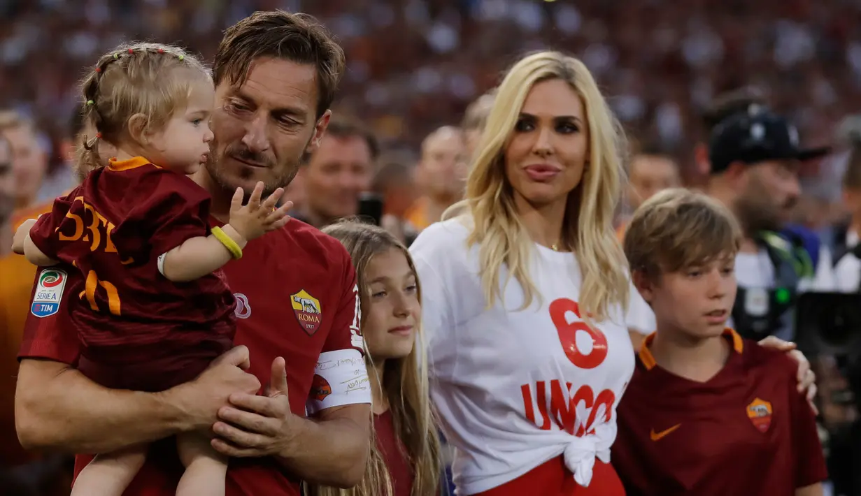 Francesco Totti bersama istri, Ilary dan anaknya mengucapkan salam perpisahan kepada pendukung AS Roma usai pertandingan terakhirnya melawan Genoa di Stadion Olimpico, Minggu (28/5). Francesco Totti resmi pensiun. (AP Photo/Alessandra Tarantino)