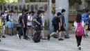 Siswa sekolah dasar mengenakan masker untuk melindungi diri dari penyebaran COVID-19 dan berjalan ke gerbang sekolah di Taipei, Taiwan, Rabu (1/9/2021). Seluruh sekolah di Taiwan kembali dibuka untuk tahun ajaran baru setelah ditutup akibat pandemi COVID-19. (AP Photo/Chiang Ying-ying)