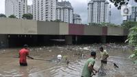 Petugas Pusat Pengelolaan Kompleks (PPK) Kemayoran membersihkan sampah yang muncul akibat banjir di Underpass Kemayoran, Jakarta, Minggu (2/2/2020). Selain melumpuhkan akses, banjir setinggi hingga 5 meter tersebut menyebabkan sampah memenuhi Underpass Kemayoran. (merdeka.com/Iqbal S. Nugroho)