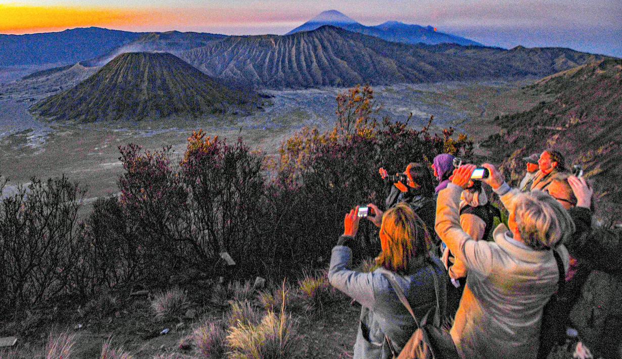 Lokasi strategis ini memberi banyak pilihan rute bagi wisatawan, sesuai dengan titik keberangkatan masing-masing. Tampak dalam foto, wisatawan mengabadikan pesona Gunung Batok di kawasan, Bromo, Jawa Timur. (merdeka.com/Arie Basuki)