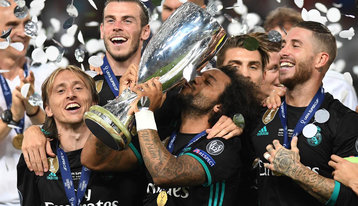 Bek Real Madrid, Marcelo, mencium trofi Piala Super Eropa usai mengalahkan Manchester United di Stadion Philip II, Skopje, Selasa (8/8/2017). Ini merupakan gelar Piala Super Eropa keempat bagi Real Madrid. (AFP/Robert Atanasovski)