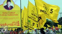 Wisatawan melintasi baliho Ade Komarudin dan bendera partai golkar di kawasan alun alun utara Yogyakarta (11/3/2016). Ade Komarudin akan mendekalrasikan pencalonan ketua Umum DPP Golkar yang akan bertarung pada Munaslub 2016. (Liputan6.com/Boy Harjanto)