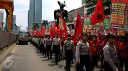 Petugas mengawal para buruh saat melakukan aksi long march menuju Istana Negara, Jakarta (31/10). Ratusan buruh meminta pemerintah mencabut PP Nomor 78 soal pengupahan yang dinilai tidak memperhatikan kesejahteraan para buruh. (Liputan6.com/Johan Tallo)