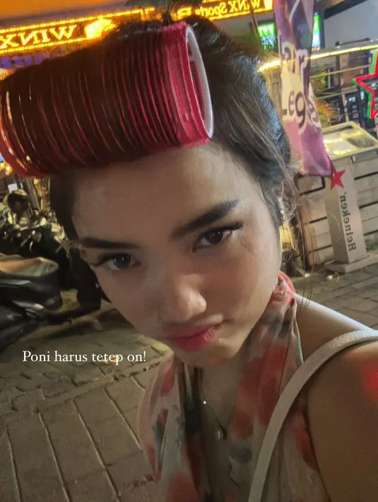 Tampak ia juga membawa tas putih dengan rollan rambut pink agar poninya tetap on point. Dengan berfoto bergaya duck face. [@fuji_an]