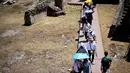 Orang-orang melindungi diri dari terik matahari dengan payung saat mengunjungi Forum di tengah gelombang panas awal musim di Roma pada Kamis 28 Mei 2026. (Tiziana FABI/AFP)