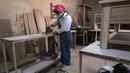 Tukang kayu Iran Sahar Biglari mengampelas sebatang kayu saat bekerja di bengkelnya di Teheran, Iran, 12 Maret 2023. Sahar, mantan guru matematika dan fisika di Iran telah mendobrak tabu untuk menjadi tukang kayu selebritas. (AP Photo/Vahid Salemi)