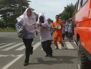 Sejumlah murid berlari saat berpartisipasi dalam latihan tsunami di Meulaboh, Aceh, (5/9). Latihan ini menyimulasikan gempa berkekuatan 9,3 di lepas pantai barat pulau Sumatra di Indonesia. (AFP Photo/Januar)