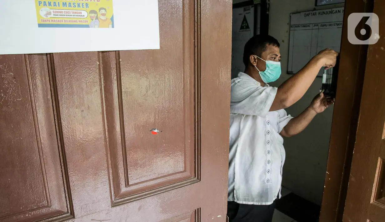 Petugas menyiapkan hand sanitizer di SMP N 115 Jakarta, Jumat (21/5/2021). Seleksi PPDB DKI Jakarta tahun ini akan dibagi menjadi empat bagian yakni jalur prestasi, jalur afirmasi, jalur zonasi, dan jalur pindah tugas orangtua dan anak guru. (Liputan6.com/Faizal Fanani)