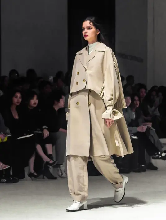 Coat coklat berstruktur dengan aksen kancing depan dan bagian belakang plisket dipadukan celana coklat. [@ikyk2011]