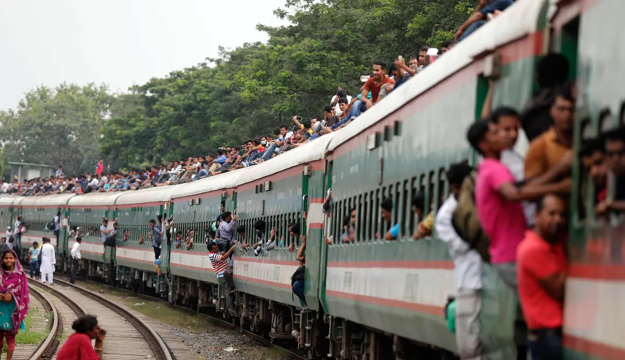 Penumpang berusaha naik ke atap kereta api saat akan pulang kampung di stasiun kereta api di Dhaka, Bangladesh, (22/6). Ribuan yang bekerja di Dhaka pulang ke kampung halamannya untuk merayakan lebaran bersama keluarganya. (AP Photo/A.M.Ahad)