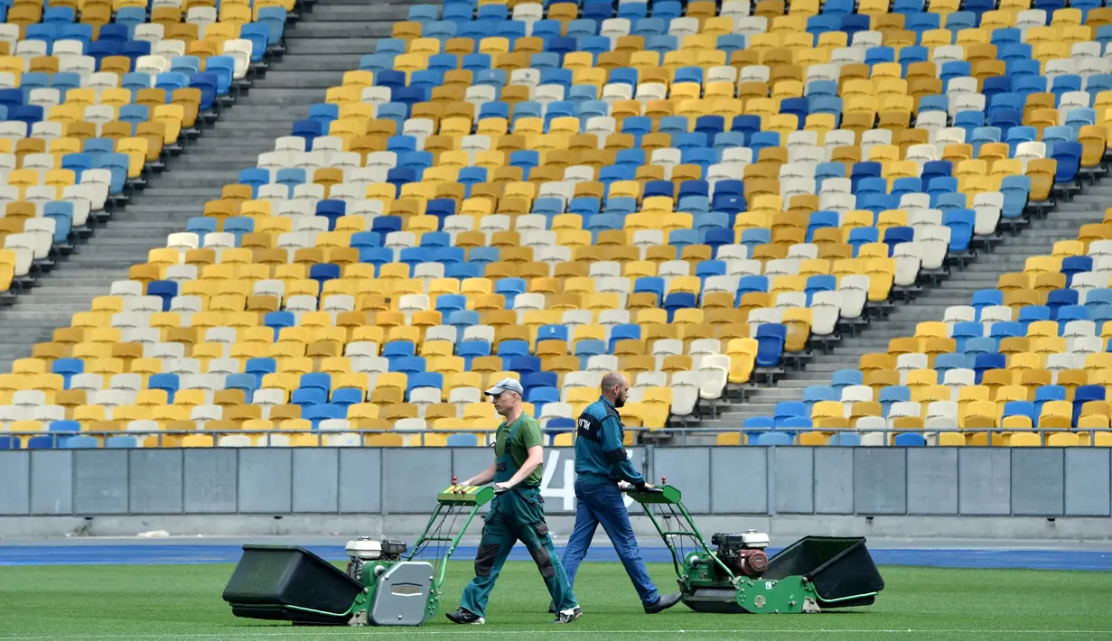 Petugas melakukan perawatan rumput di stadion NSC Olimpiyskiy, Kiev, Senin (14/5). Stadion NSC Olimpiyskiy ini telah ditujuk UEFA sebagai venue final Liga Champions 2018 antara Real Madrid vs Liverpool pada 26 Mei mendatang. (AFP/Sergei SUPINSKY)