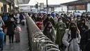 Penumpang tiba di stasiun kereta api Hongqiao di Shanghai (20/1/2023). Migrasi tahunan dimulai dengan jutaan orang kembali ke kampung halaman mereka untuk perayaan Tahun Baru Imlek. (AFP/Hector Retamal)