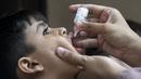 <p>Petugas kesehatan memberikan vaksin polio kepada seorang anak selama kampanye vaksinasi polio dari pintu ke pintu di daerah kumuh di Karachi, Paksistan, Senin (23/5/2022). Pakistan meluncurkan upaya anti-polio baru pada hari Senin, lebih dari seminggu setelah pejabat mendeteksi kasus ketiga tahun ini di wilayah barat laut negara itu yang berbatasan dengan Afghanistan. (Asif HASSAN / AFP)</p>