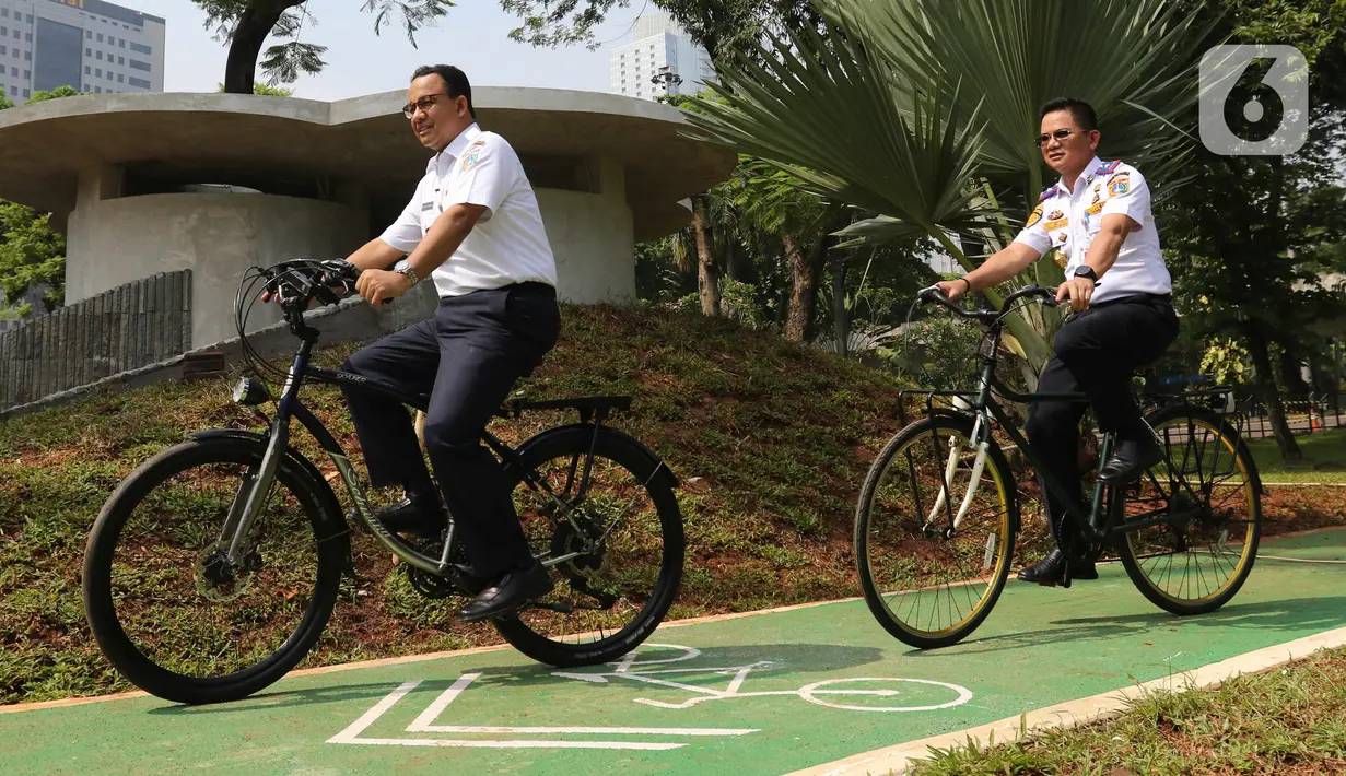 Gubernur DKI Jakarta Anies Baswedan bersepeda di jalur sepeda saat soft launching fasilitas pejalan kaki dan pesepeda pada proyek pembangunan dan penataan kawasan Semanggi di Taman Semanggi, Jakarta, Rabu (12/10/2022). Anies menjajal jalur sepeda itu bersama Kepala Dinas Perhubungan DKI Syafrin Liputo. (Liputan6.com/Herman Zakharia)