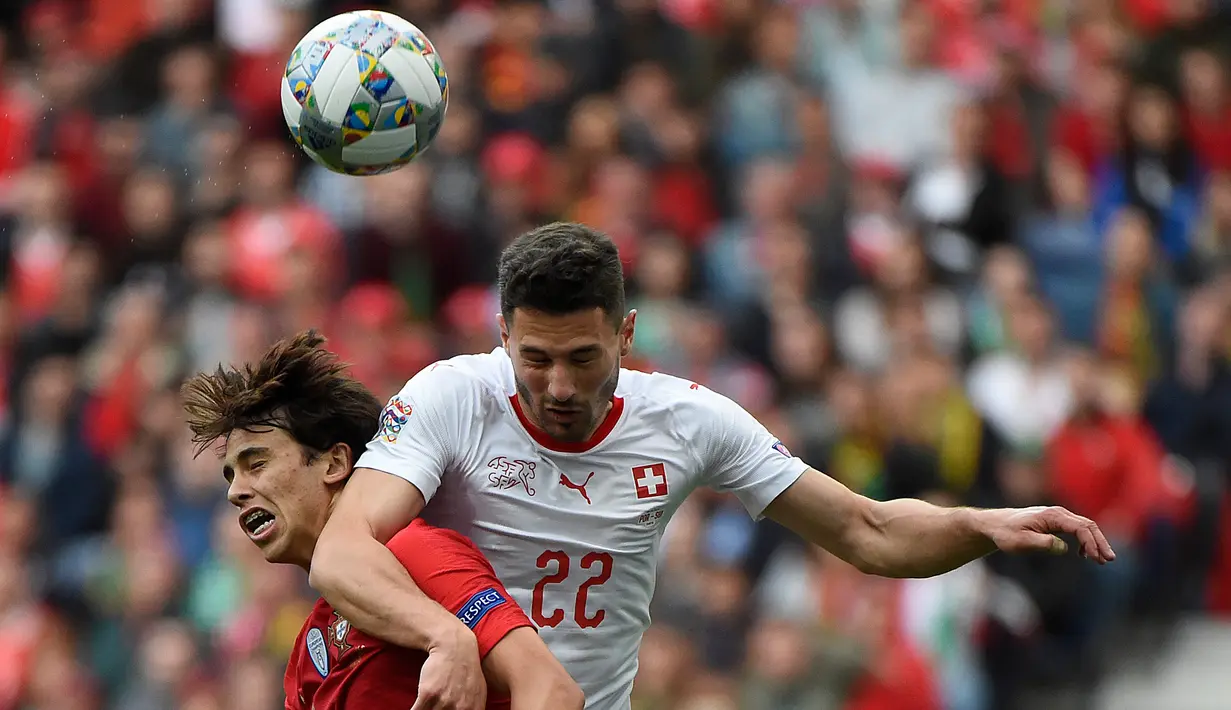Gelandang Portugal, Joao Felix berebut bola udara dengan Bek Swiss, Fabian Schar selama pertandingan semifinal Liga Bangsa-Bangsa UEFA di stadion Dragao di Porto pada 5 Juni 2019. (AFP Photo/Miguel Riopa)