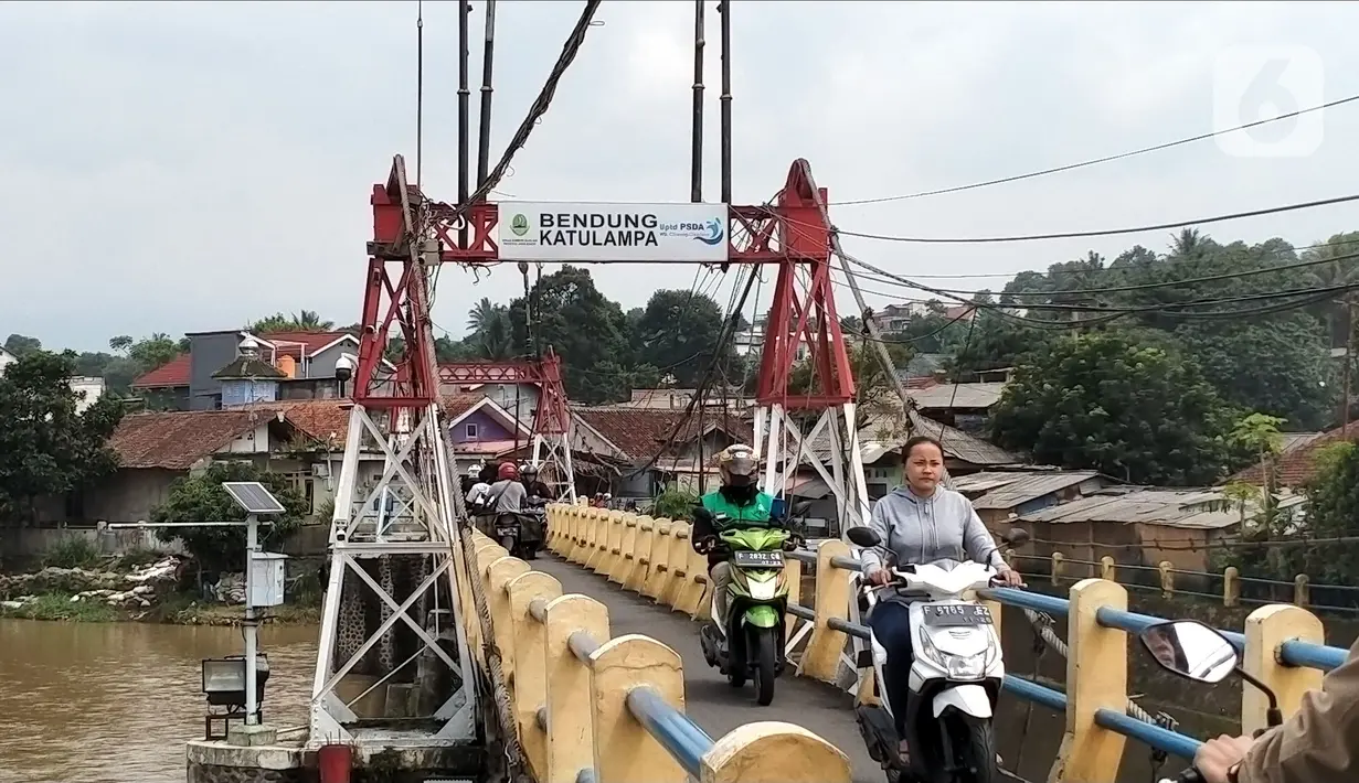 Pengendara sepeda motor melintasi Bendung Katulampa, Bogor, Jawa Barat, Senin (10/10/2022). Setelah sebelumnya tinggi muka air (TMA) mencapai 220 Cm dengan status Siaga 1, pada pukul 13.23 WIB Bendung Katulampa terpantau kembali pada status normal. (Liputan.com/Magang/Aida Nuralifa)