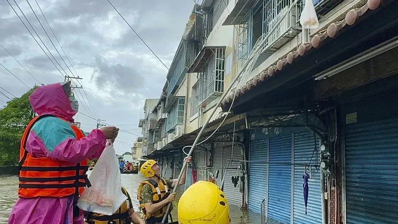 Petugas SAR bagikan barang yang dibutuhkan oleh warga yang terjebak banjir akibat Topan Gaemi di Chiayi, Taiwan, Jumat (26/7/2024). (Taiwan Ministry of National Defense via AP)